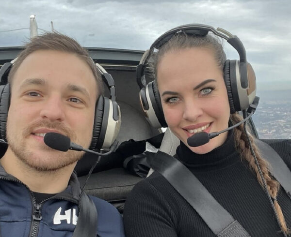 Two pilots taking a selfie in the cockpit of a small aircraft wearing Lightspeed Aviation's Zulu 3 and Lightspeed Delta Zulu headsets